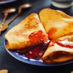 a plate of food with crepes and sauce on it