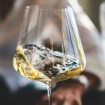 clear wine glass with yellow liquid